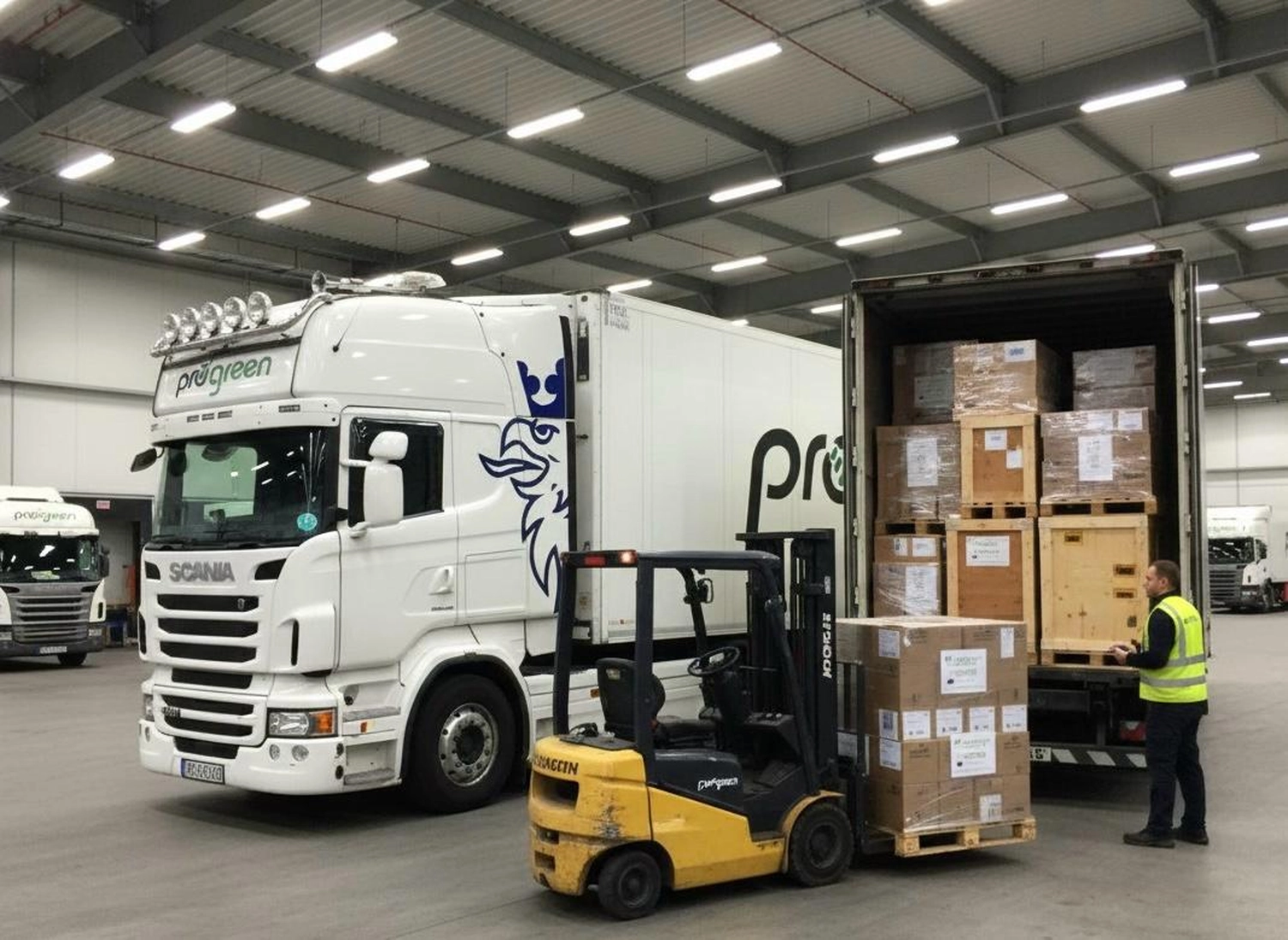 Progreen GmbH – Logistik – Diese Abbildung zeigt einen Scania-Sattelzug der R-Serie, der in einem Lager mit Fracht beladen wird.
